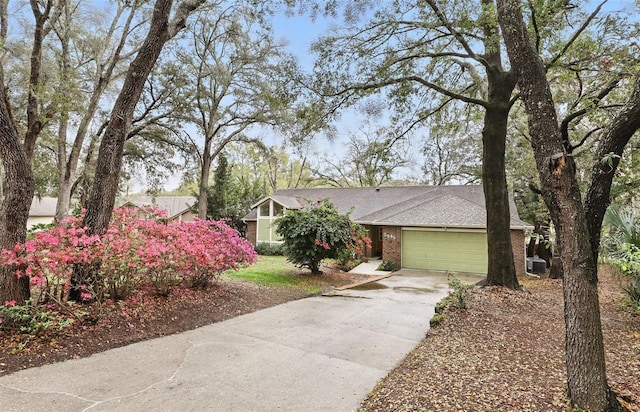 view of front of home featuring a shingled roof, concrete driveway, brick siding, and an attached garage