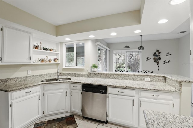 kitchen with a peninsula, stainless steel dishwasher, a sink, and white cabinetry