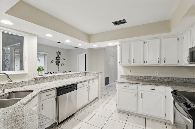 kitchen with light stone counters, stainless steel appliances, visible vents, white cabinets, and a sink