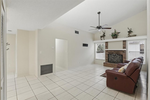 living room with a brick fireplace, visible vents, vaulted ceiling, and light tile patterned floors