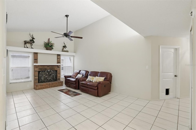 living room featuring lofted ceiling, ceiling fan, light tile patterned floors, and a brick fireplace