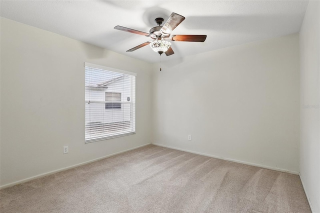 unfurnished room featuring light carpet, ceiling fan, and baseboards