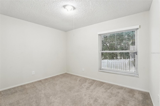 unfurnished room featuring a textured ceiling, baseboards, and carpet flooring