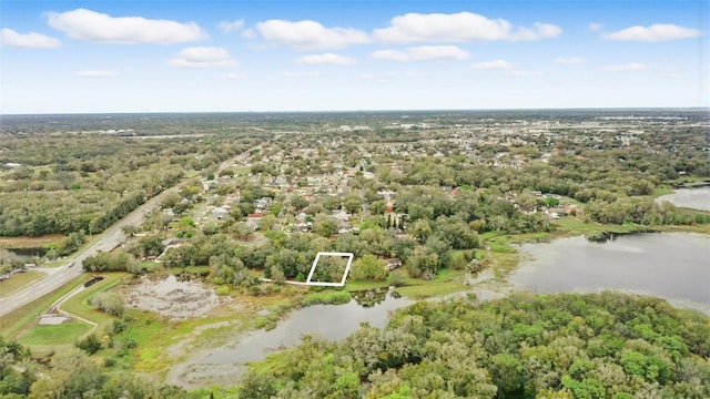 drone / aerial view featuring a water view and a wooded view