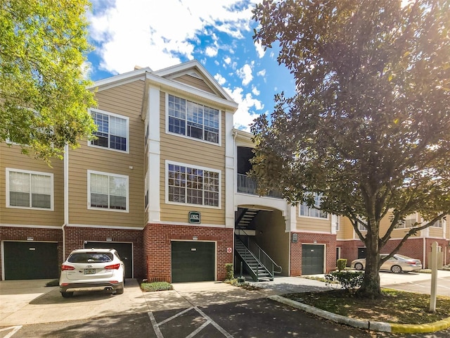 view of property featuring driveway, stairway, and an attached garage