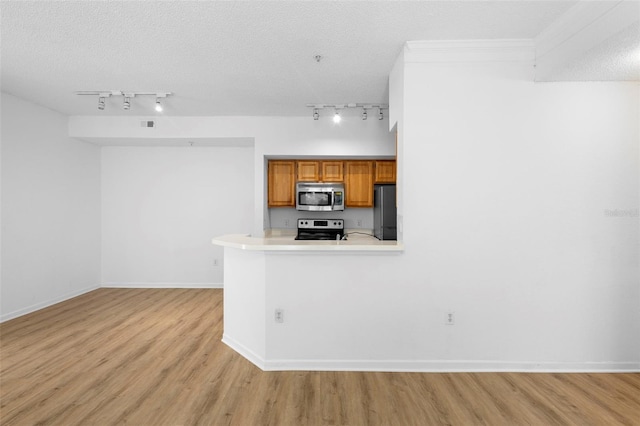 13037 Mulberry Park Dr Unit 529, Orlando, FL 32821 - kitchen featuring stainless steel microwave, track lighting, freestanding refrigerator, electric range, and brown cabinetry