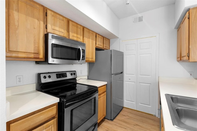 13037 Mulberry Park Dr Unit 529, Orlando, FL 32821 - kitchen featuring appliances with stainless steel finishes, light wood-style floors, and light countertops