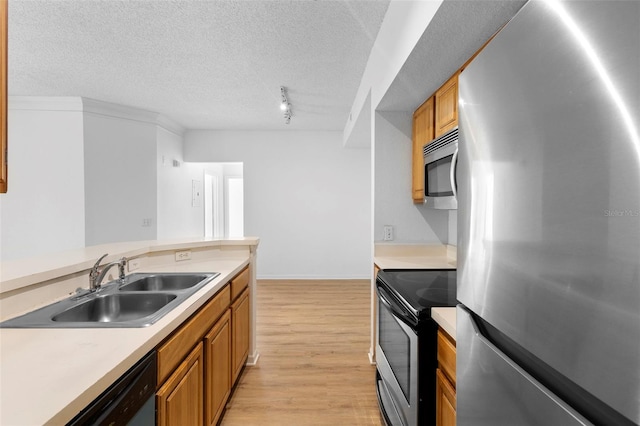 13037 Mulberry Park Dr Unit 529, Orlando, FL 32821 - kitchen with stainless steel appliances, light wood-style floors, brown cabinetry, track lighting, and light countertops