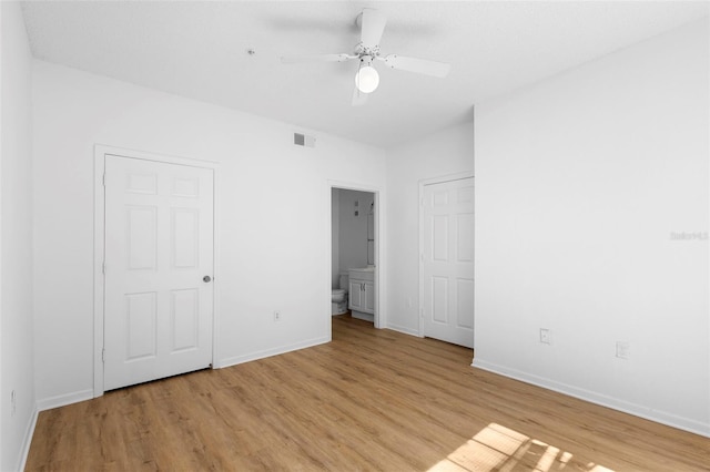 13037 Mulberry Park Dr Unit 529, Orlando, FL 32821 - unfurnished bedroom featuring light wood-style floors, ensuite bathroom, and a ceiling fan