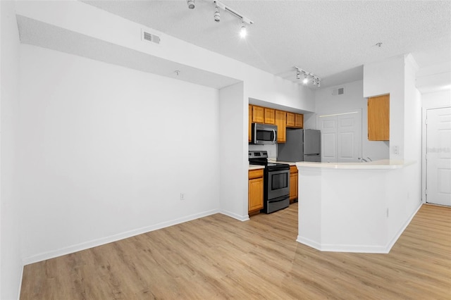 13037 Mulberry Park Dr Unit 529, Orlando, FL 32821 - kitchen with stainless steel appliances, rail lighting, light wood finished floors, light countertops, and brown cabinetry