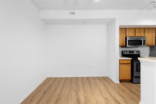 13037 Mulberry Park Dr Unit 529, Orlando, FL 32821 - kitchen featuring stainless steel appliances, light wood finished floors, light countertops, and brown cabinetry