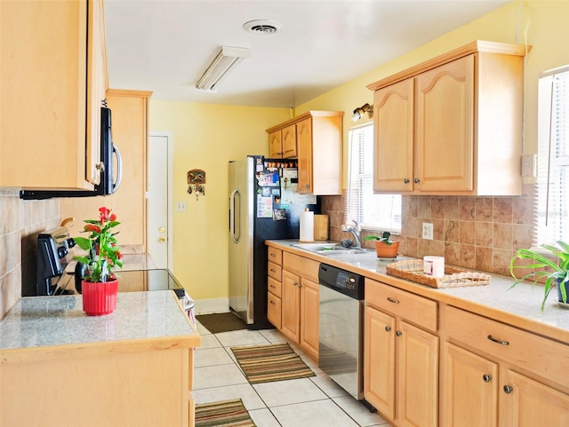 kitchen with light tile patterned floors, stainless steel appliances, a sink, visible vents, and light brown cabinetry