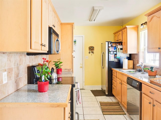 kitchen with appliances with stainless steel finishes, light tile patterned flooring, a sink, and light brown cabinetry