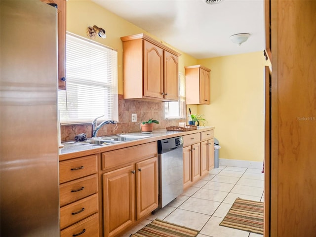 kitchen featuring a sink, light countertops, appliances with stainless steel finishes, light brown cabinetry, and plenty of natural light