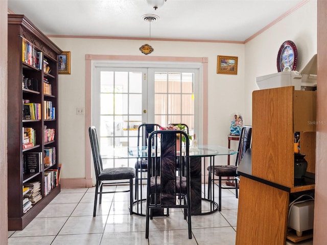 dining space with light tile patterned floors, french doors, visible vents, and crown molding