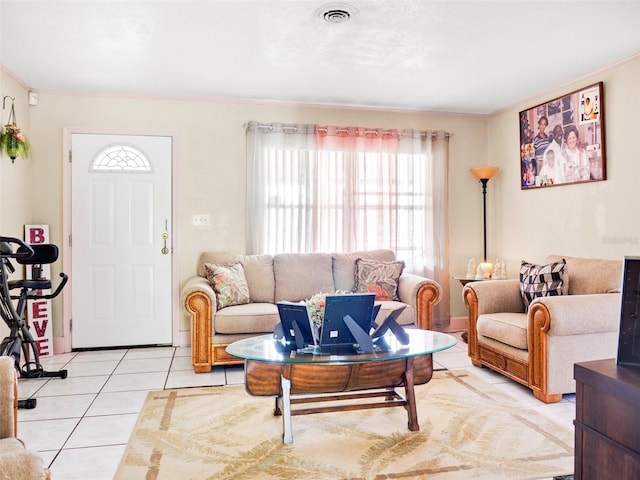 living area featuring ornamental molding, visible vents, and light tile patterned floors