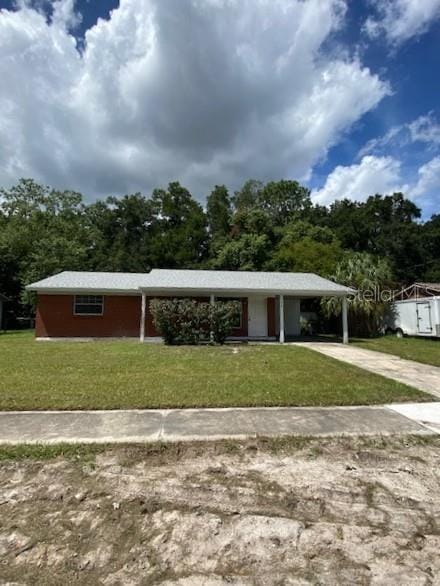 surrounding community featuring an attached carport, concrete driveway, and a yard