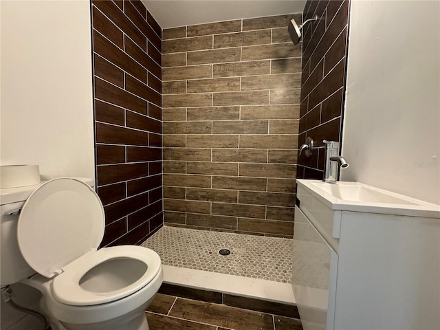 full bathroom featuring a shower stall, toilet, and vanity