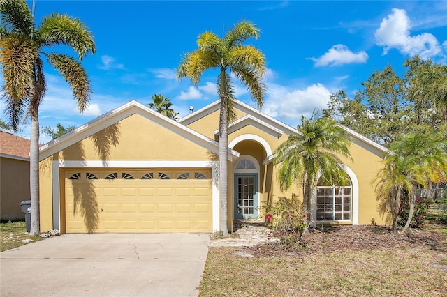 view of front of home featuring a garage, concrete driveway, and stucco siding