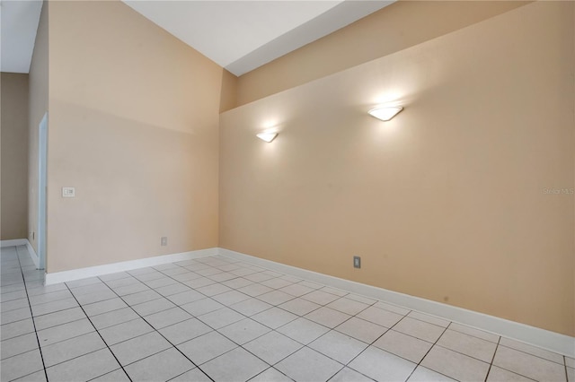 spare room with light tile patterned floors and baseboards