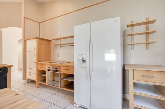 kitchen with black appliances, arched walkways, open shelves, and light tile patterned flooring