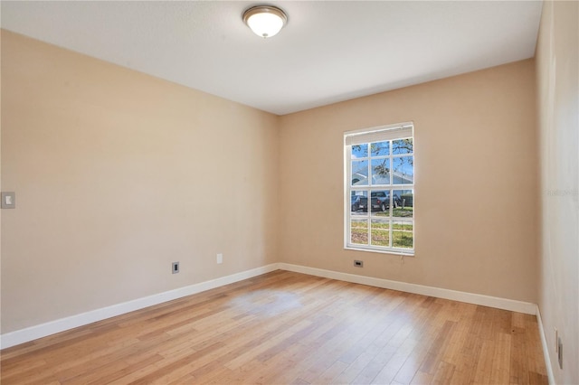 spare room with light wood-type flooring and baseboards