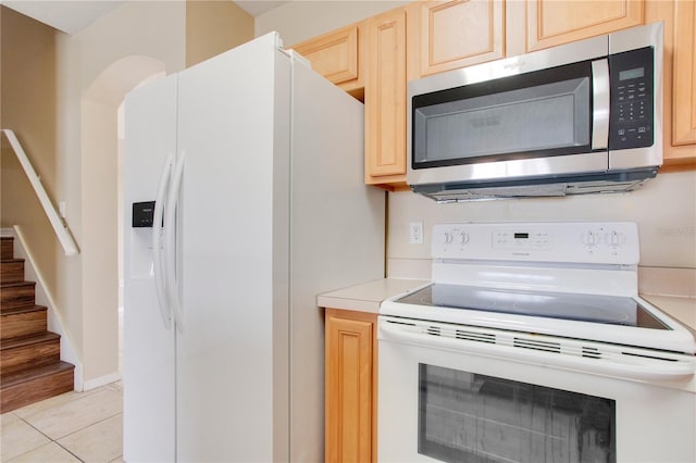 kitchen with white appliances, light tile patterned flooring, light countertops, and light brown cabinetry