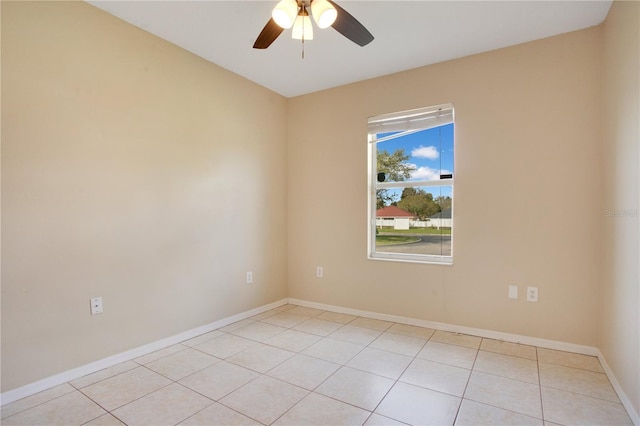 spare room with ceiling fan, light tile patterned floors, and baseboards