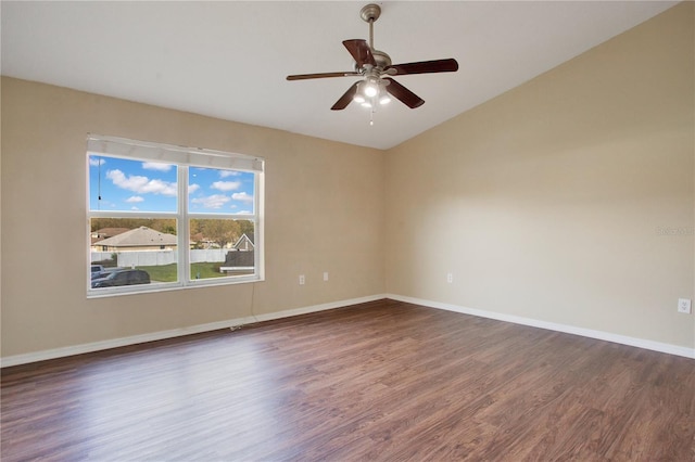 spare room with vaulted ceiling, ceiling fan, wood finished floors, and baseboards