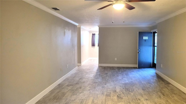 unfurnished room featuring baseboards, visible vents, wood finished floors, and ornamental molding