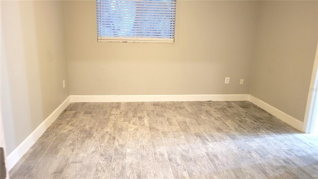 empty room with baseboards and wood finished floors