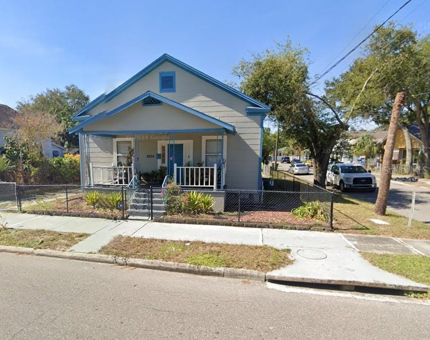 bungalow-style house with covered porch and a fenced front yard