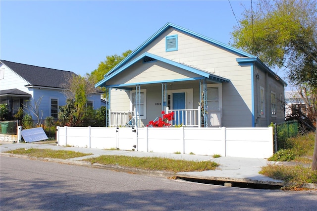 bungalow-style house featuring a fenced front yard, covered porch, and a gate