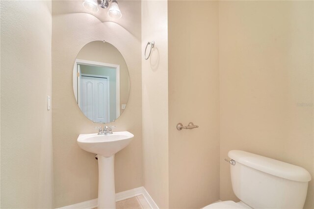 bathroom featuring baseboards and toilet