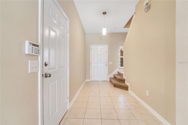 foyer with light tile patterned floors, stairway, and baseboards