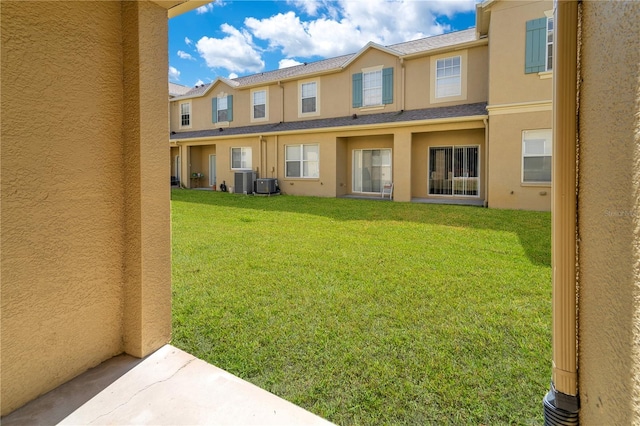 exterior space with a yard, central AC, and stucco siding