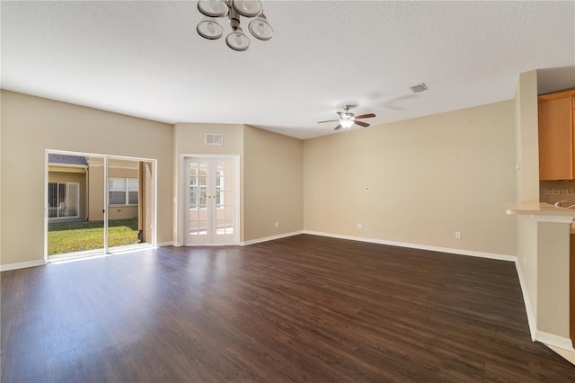 unfurnished living room featuring dark wood-type flooring, french doors, visible vents, and baseboards