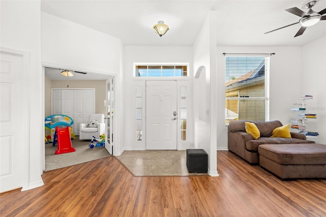 entrance foyer with wood finished floors, a ceiling fan, and baseboards