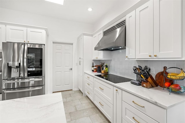 kitchen featuring wall chimney range hood, black electric cooktop, white cabinetry, and stainless steel refrigerator with ice dispenser