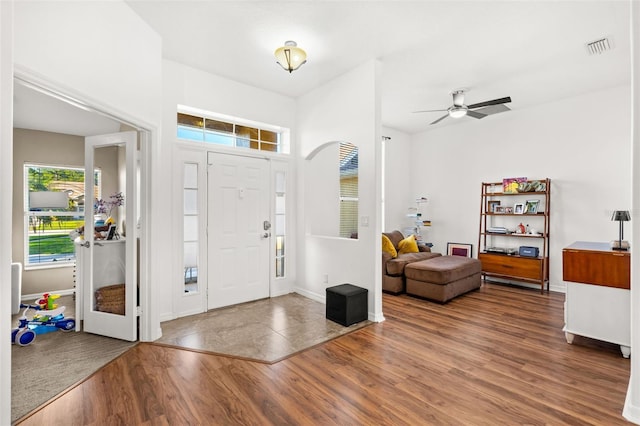 entryway featuring baseboards, visible vents, ceiling fan, and wood finished floors