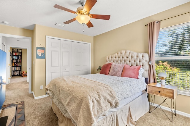 bedroom with a closet, visible vents, light carpet, and baseboards