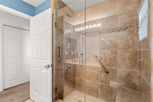 full bathroom with a closet, a shower stall, and a textured ceiling