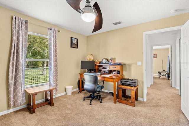 office space with light carpet, ceiling fan, visible vents, and baseboards