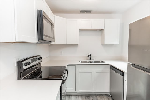 kitchen with white cabinetry, stainless steel appliances, and light countertops