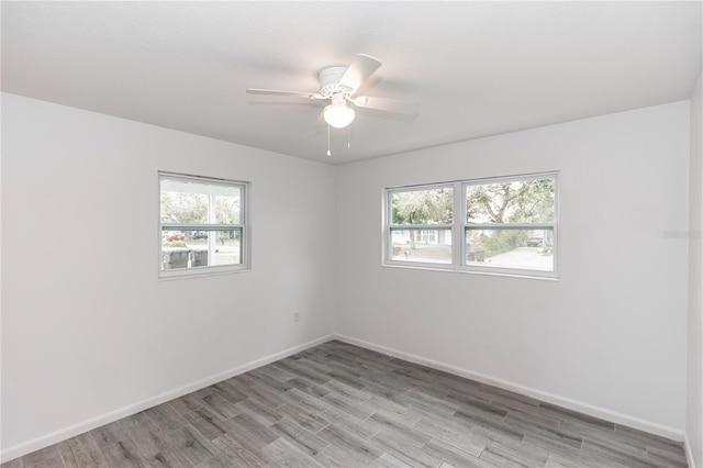 unfurnished room featuring ceiling fan, light wood-style flooring, and baseboards