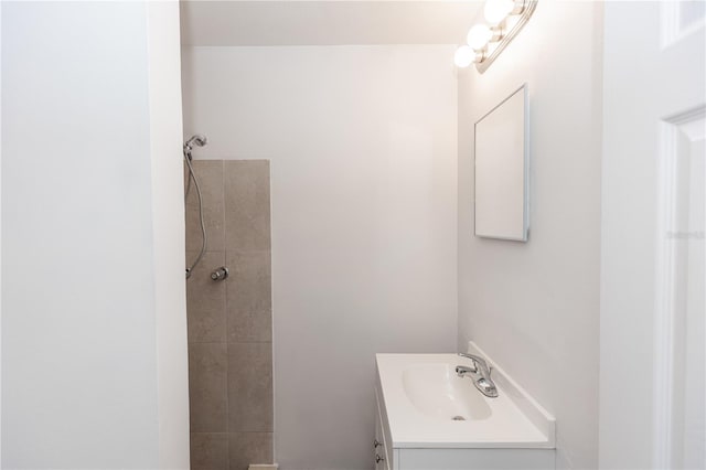 bathroom featuring a tile shower and vanity