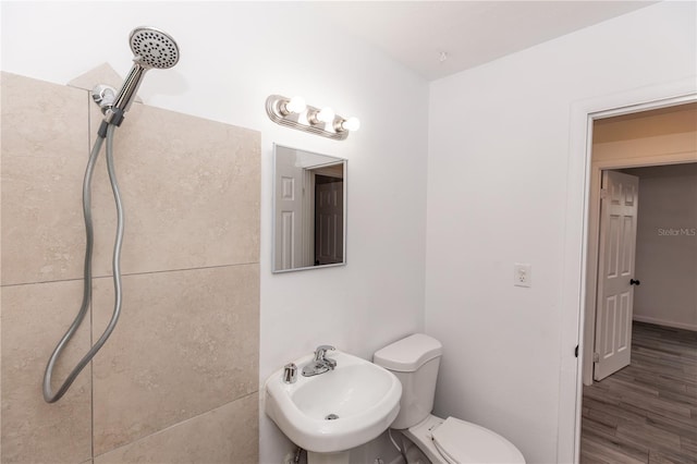 bathroom with toilet, a shower, a sink, and wood finished floors