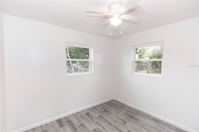 unfurnished room with light wood-type flooring, plenty of natural light, and baseboards