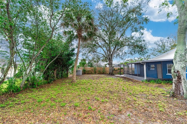 view of yard featuring a sunroom and fence