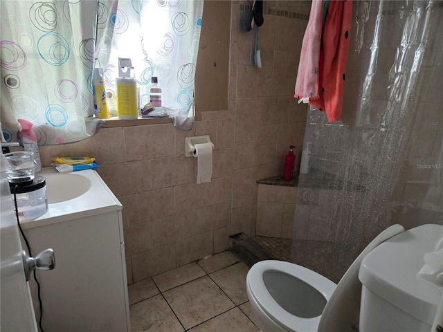 bathroom featuring a stall shower, tile patterned floors, toilet, and tile walls